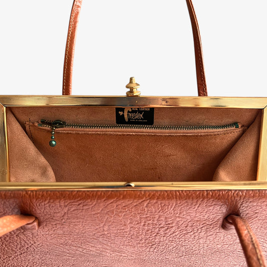 Made in England Freedex label inside of a vintage 1950s small orange leather frame bag.