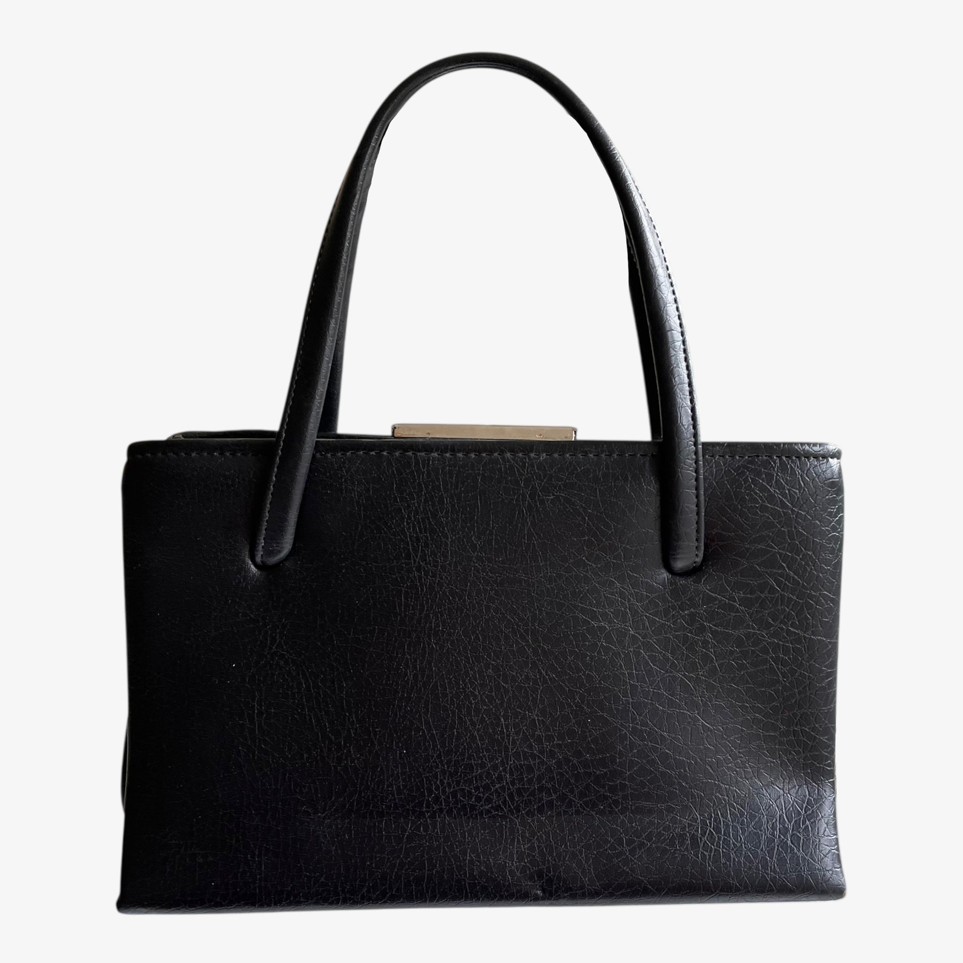 Vintage 1960s black pebbled leather shoulder bag on a white background.