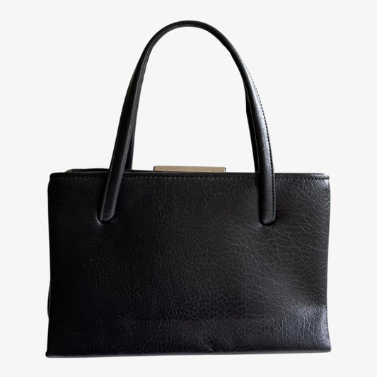 Vintage 1960s black pebbled leather shoulder bag on a white background.