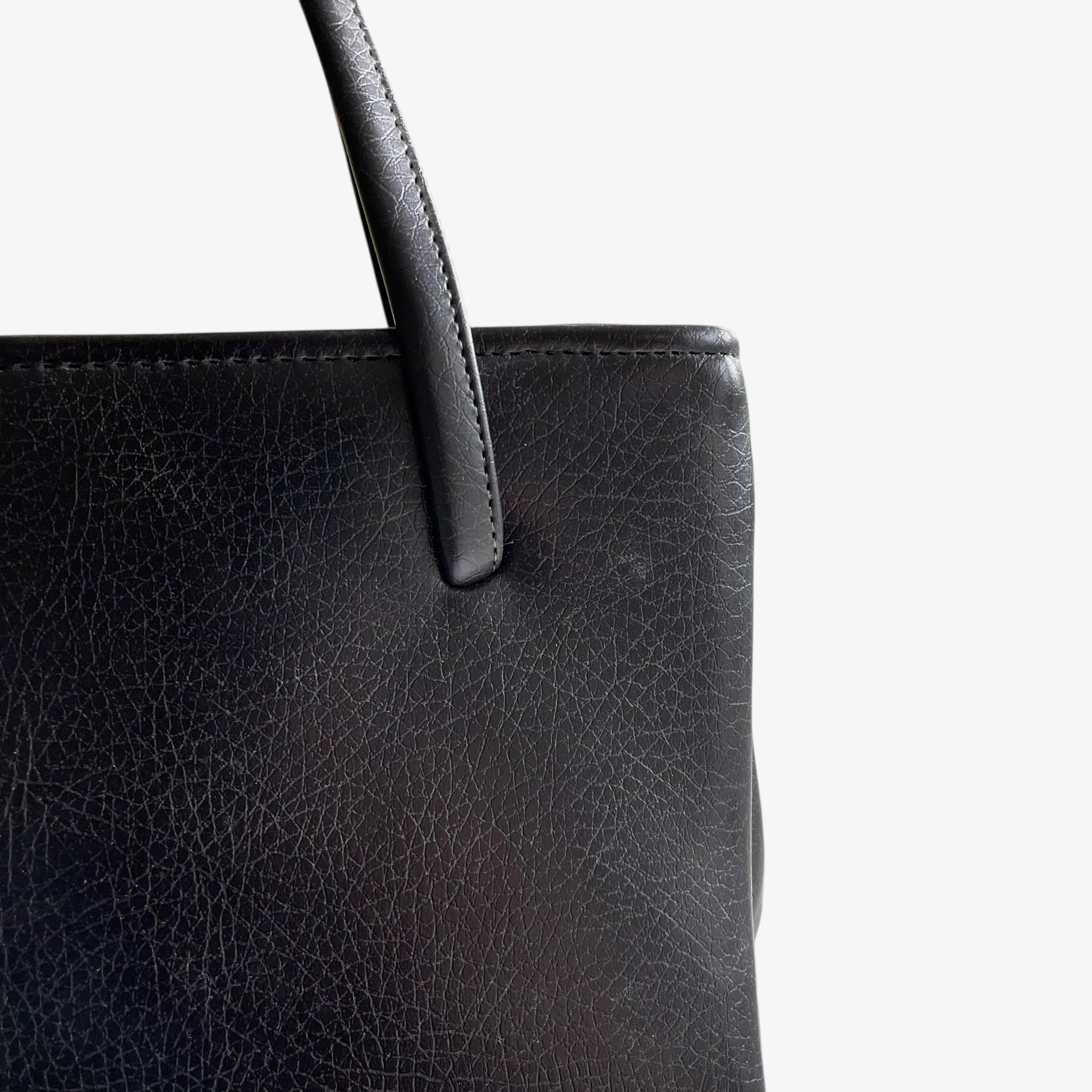 Close up of black pebbled leather on a vintage 1960s shoulder bag.