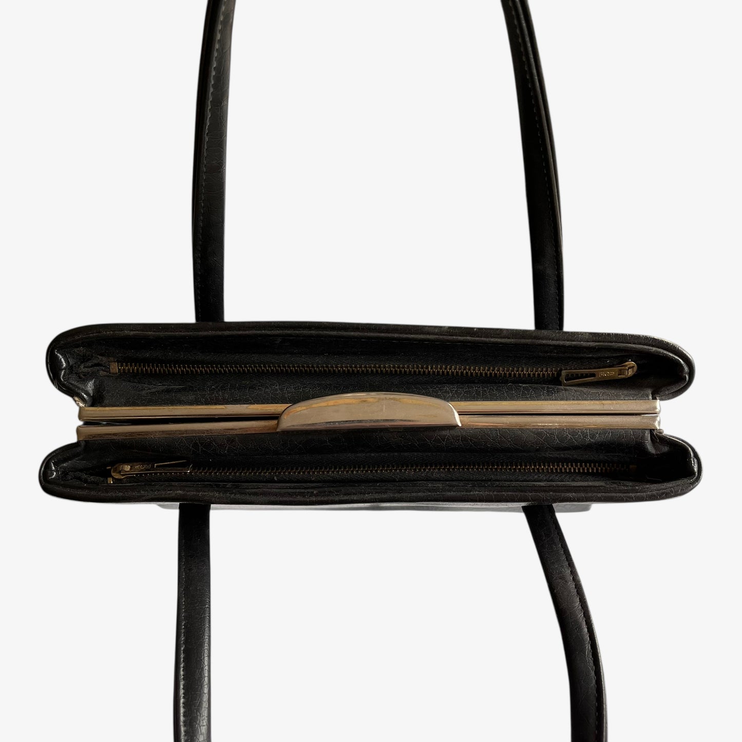 Inside of a vintage 1960s black pebbled leather shoulder bag.