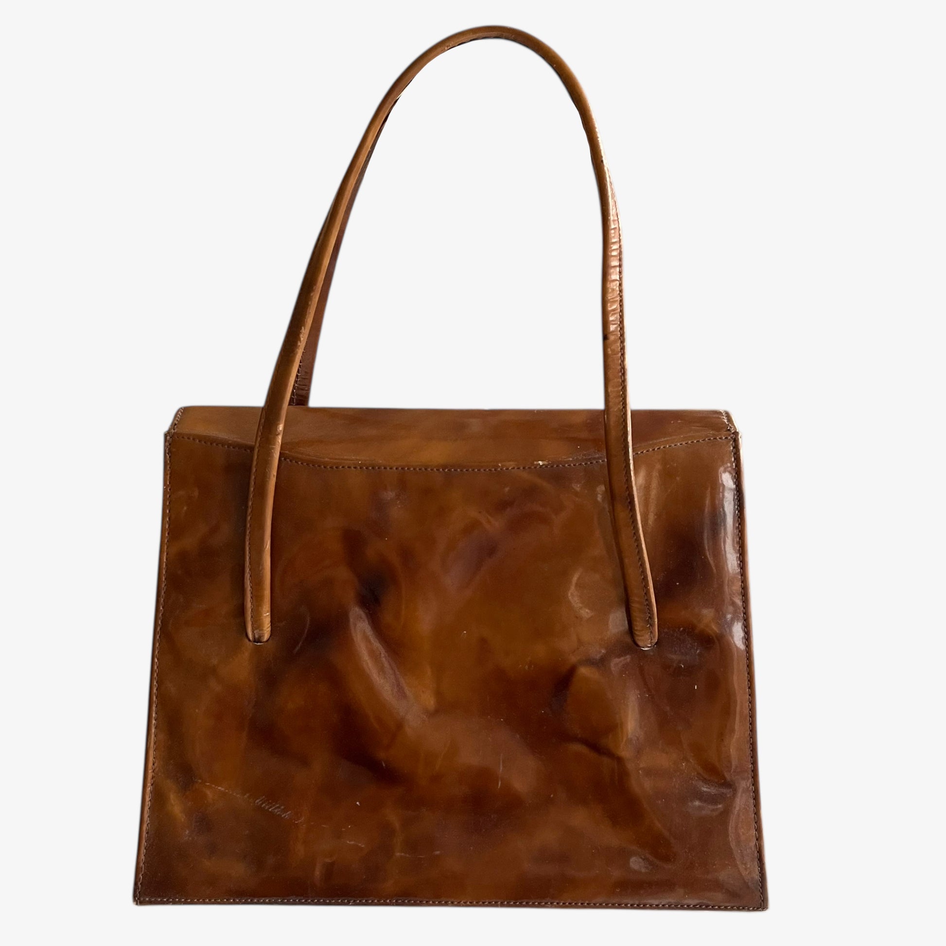 Back of vintage 1960s misty cognac brown faux leather flap on a white background.