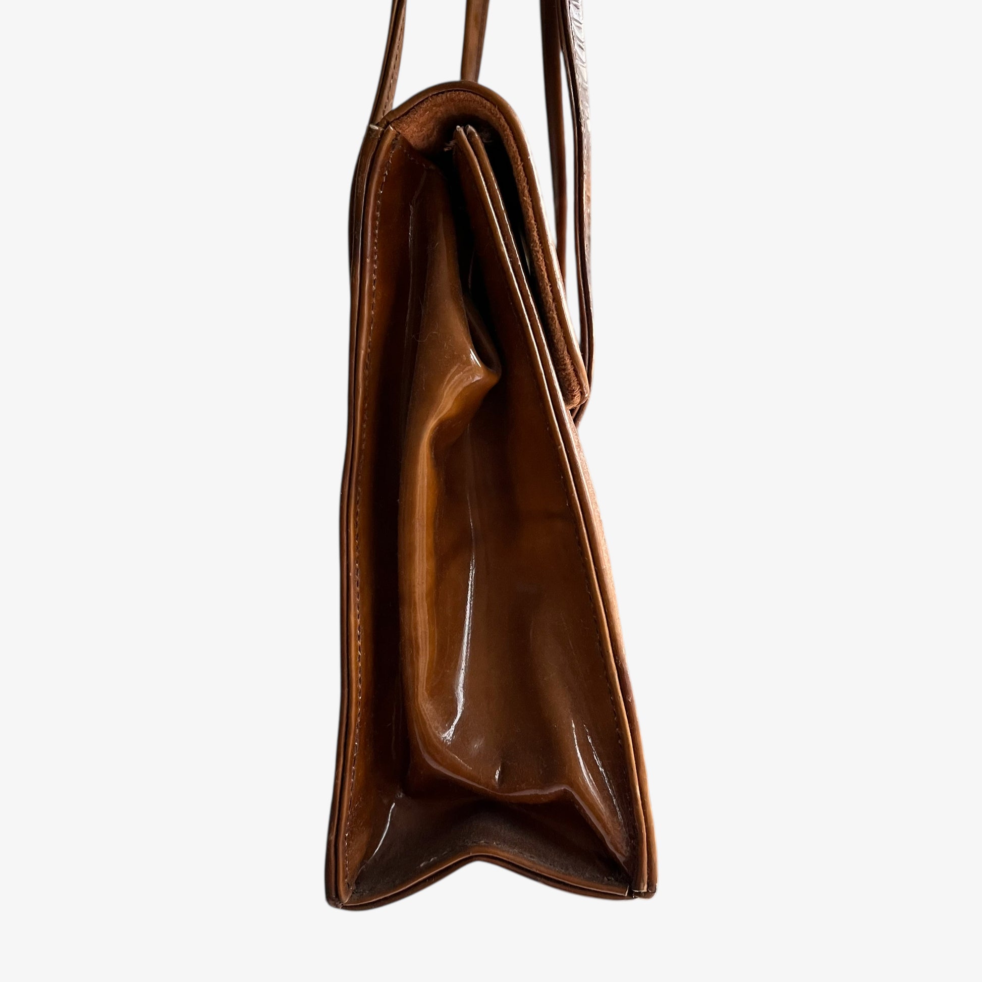 Side view of a vintage 1960s misty cognac brown faux leather flap.