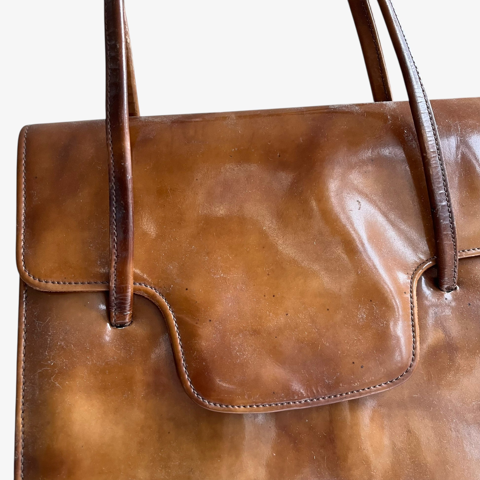 Close up of detailed stitching on a vintage 1960s misty cognac brown faux leather flap.