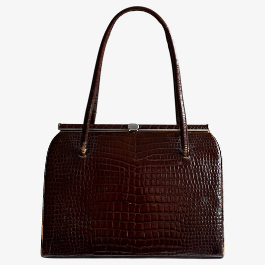 Vintage 50s crocodile embossed brown leather shoulder bag on a white background.