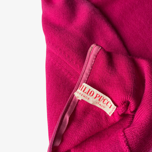 Close up of a pink sweater with a 1960s Emilio Pucci label on a white background.