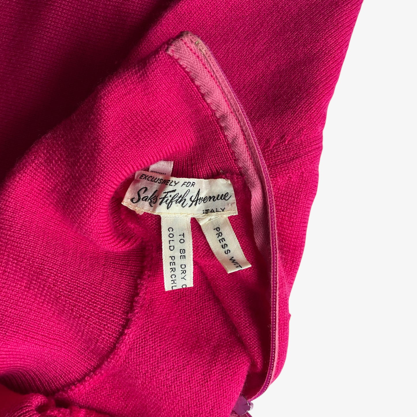 Close up of a Saks Fifth Avenue label inside of a vintage 60s women's Emilio Pucci pink turtleneck jumper.
