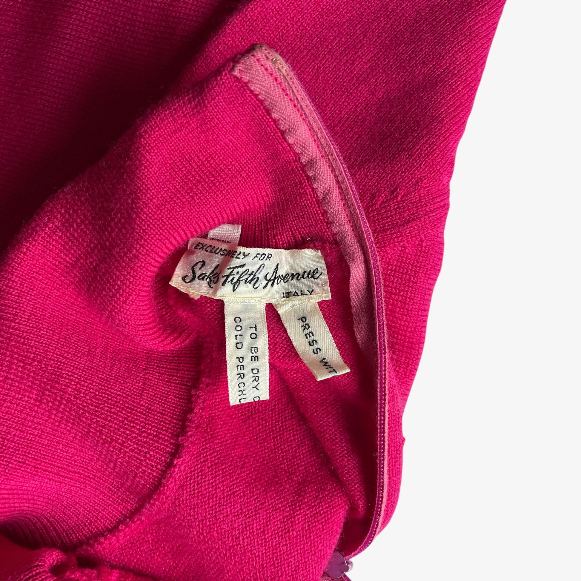 Close up of a Saks Fifth Avenue label inside of a vintage 60s women's Emilio Pucci pink turtleneck jumper.