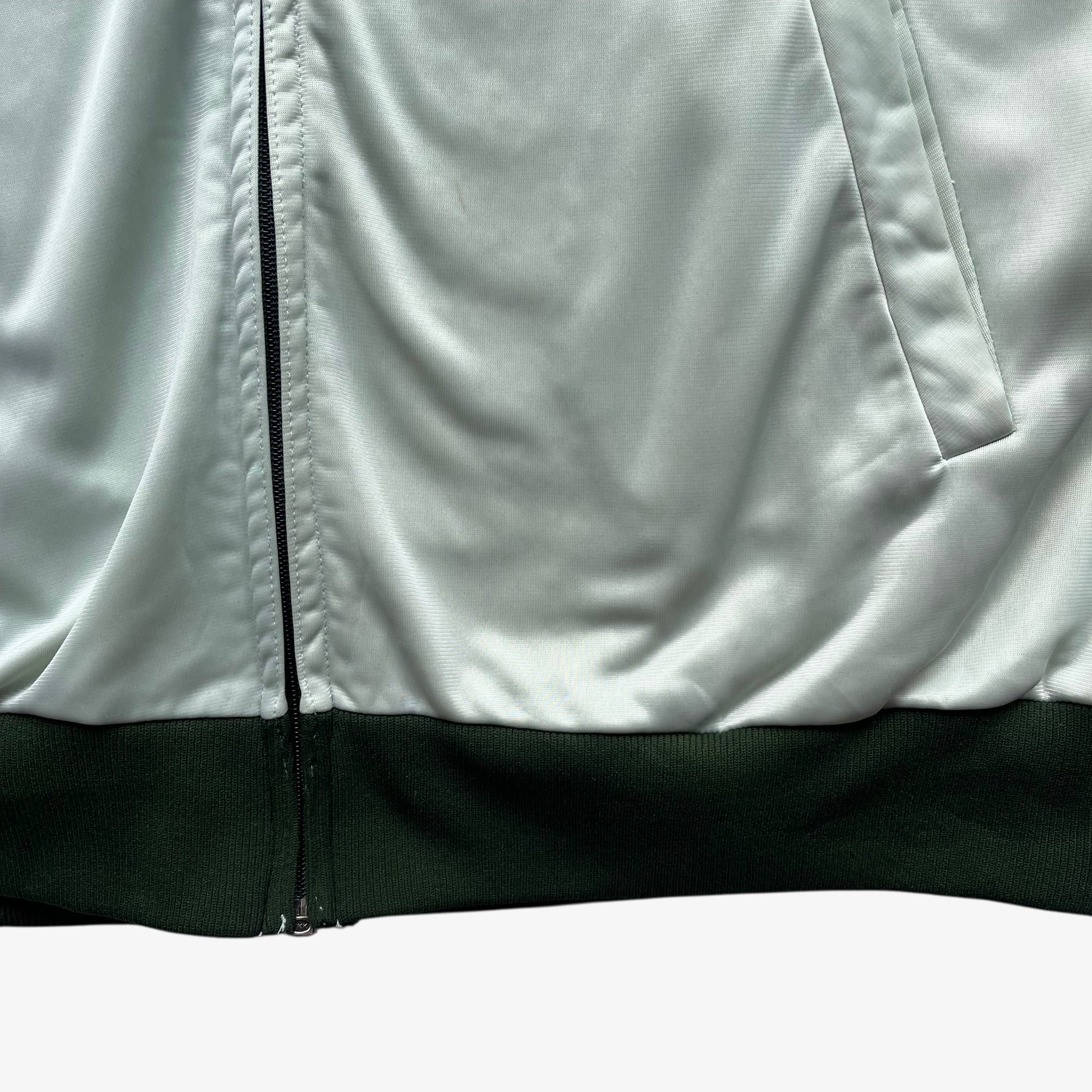 Hem of men's vintage 70s Adidas ATP Keyrolan green track jacket.