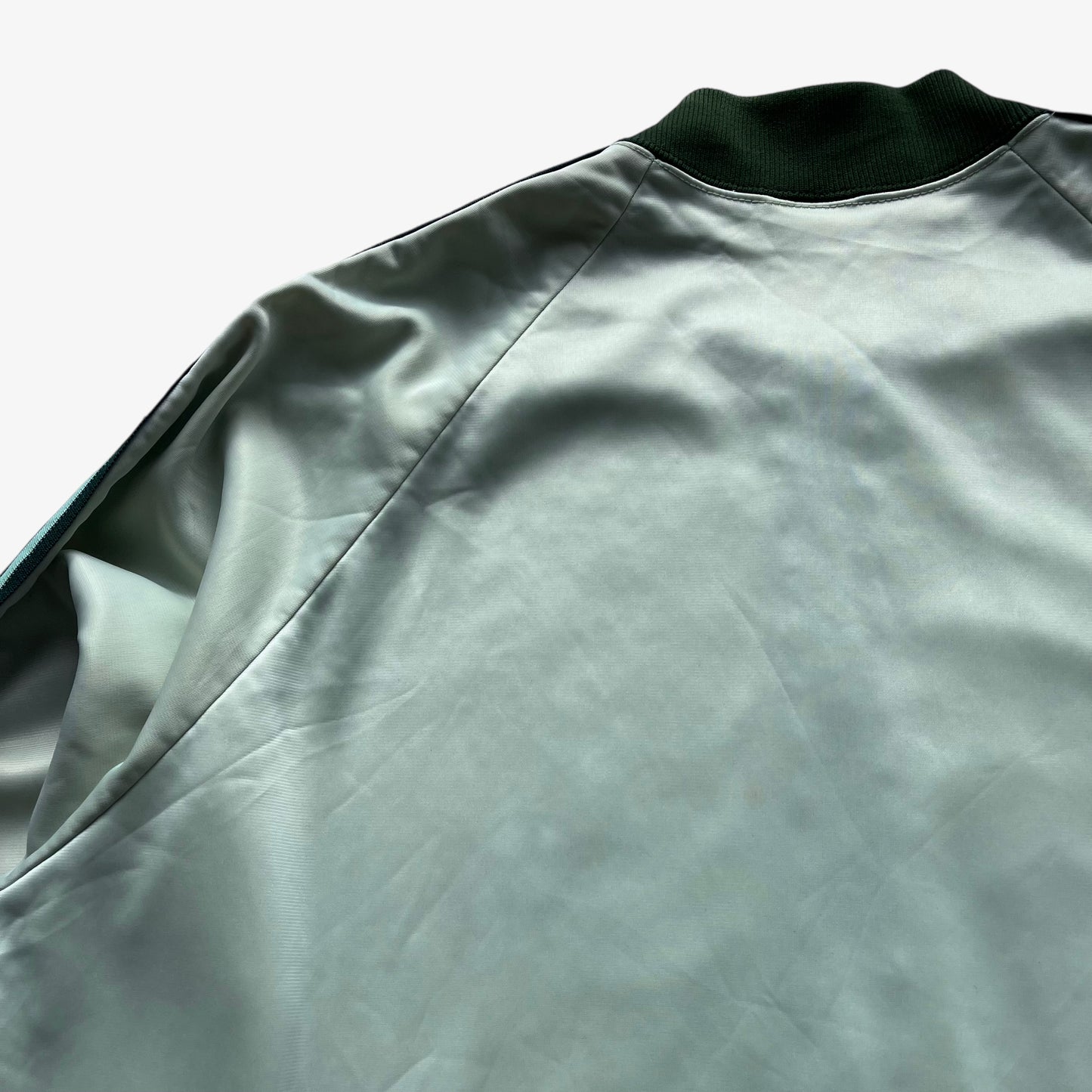 Patina on men's vintage 70s Adidas ATP Keyrolan green track jacket.