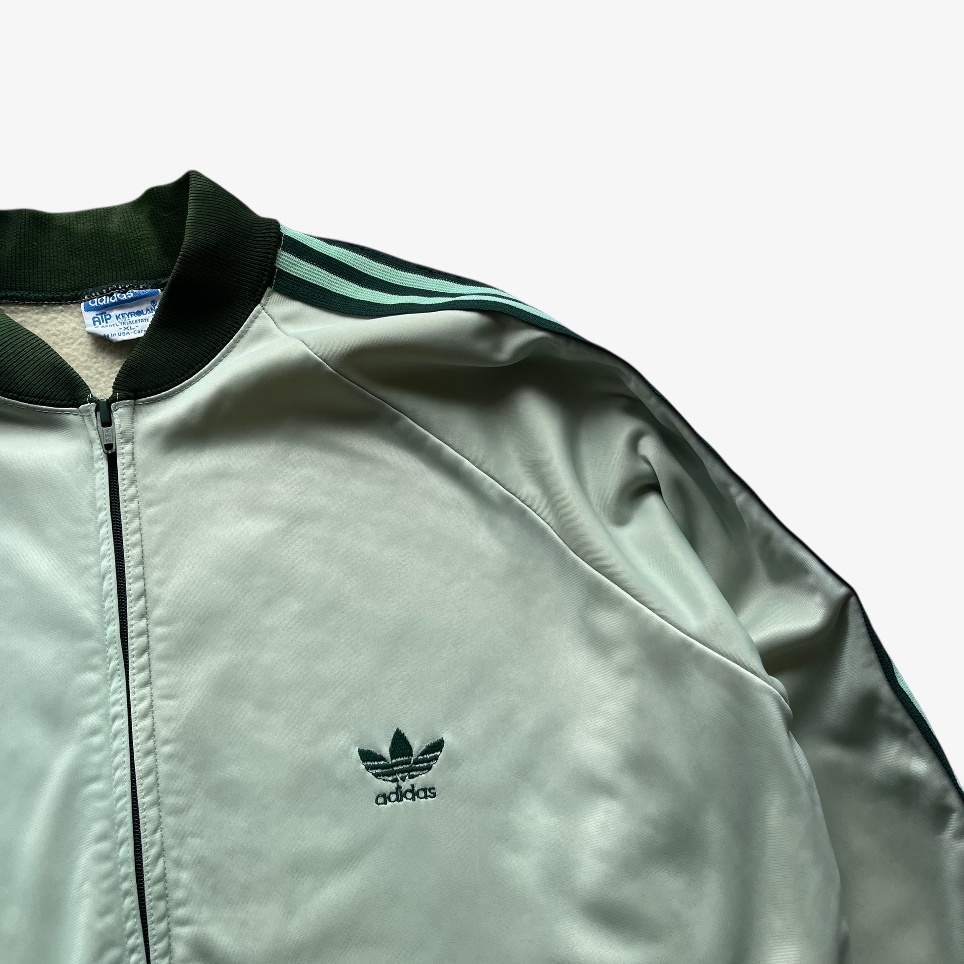 Embroidered trefoil logo on men's vintage 70s Adidas ATP Keyrolan green track jacket.