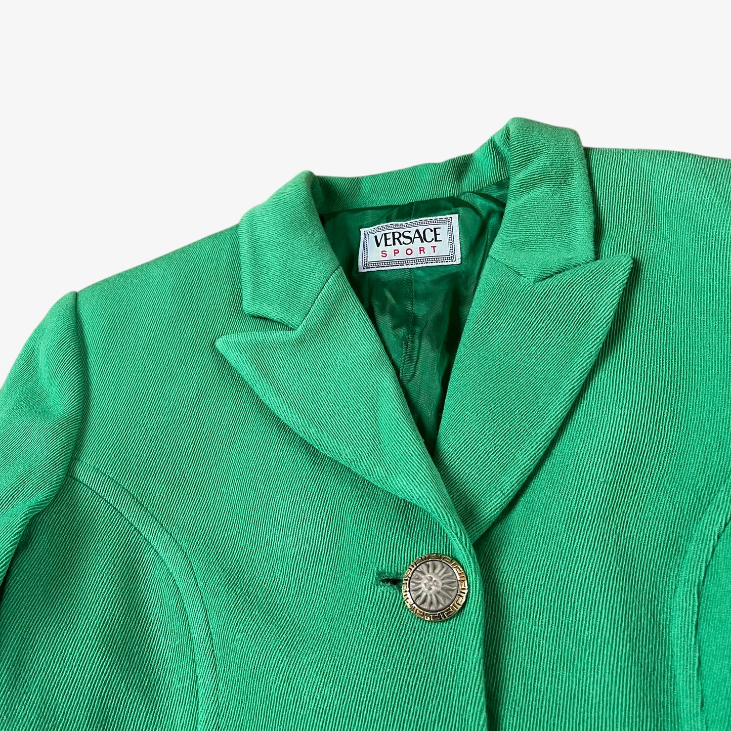 Vintage 70s Versace Sport women’s green wool blazer with sun-engraved gold buttons.