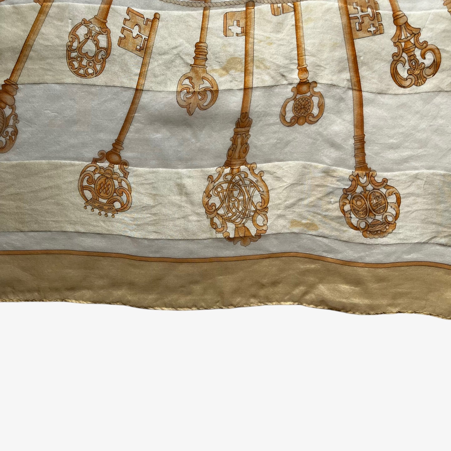 Patina on a women's vintage 80s Balenciaga Paris yellow silk scarf with a gold baroque style key print.