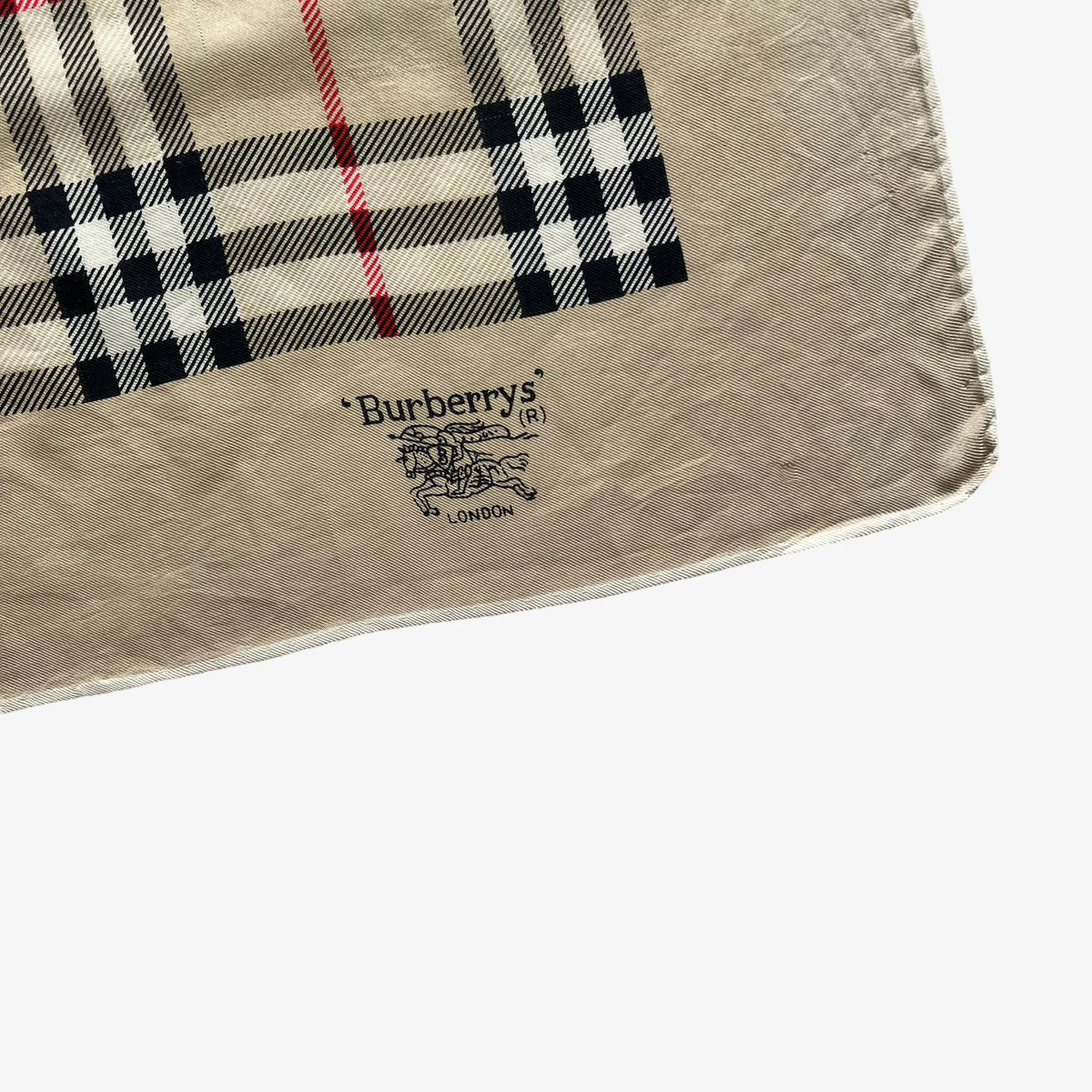Close up of Burberrys trademark logo on women's vintage 80s Burberry London nova check print silk scarf.