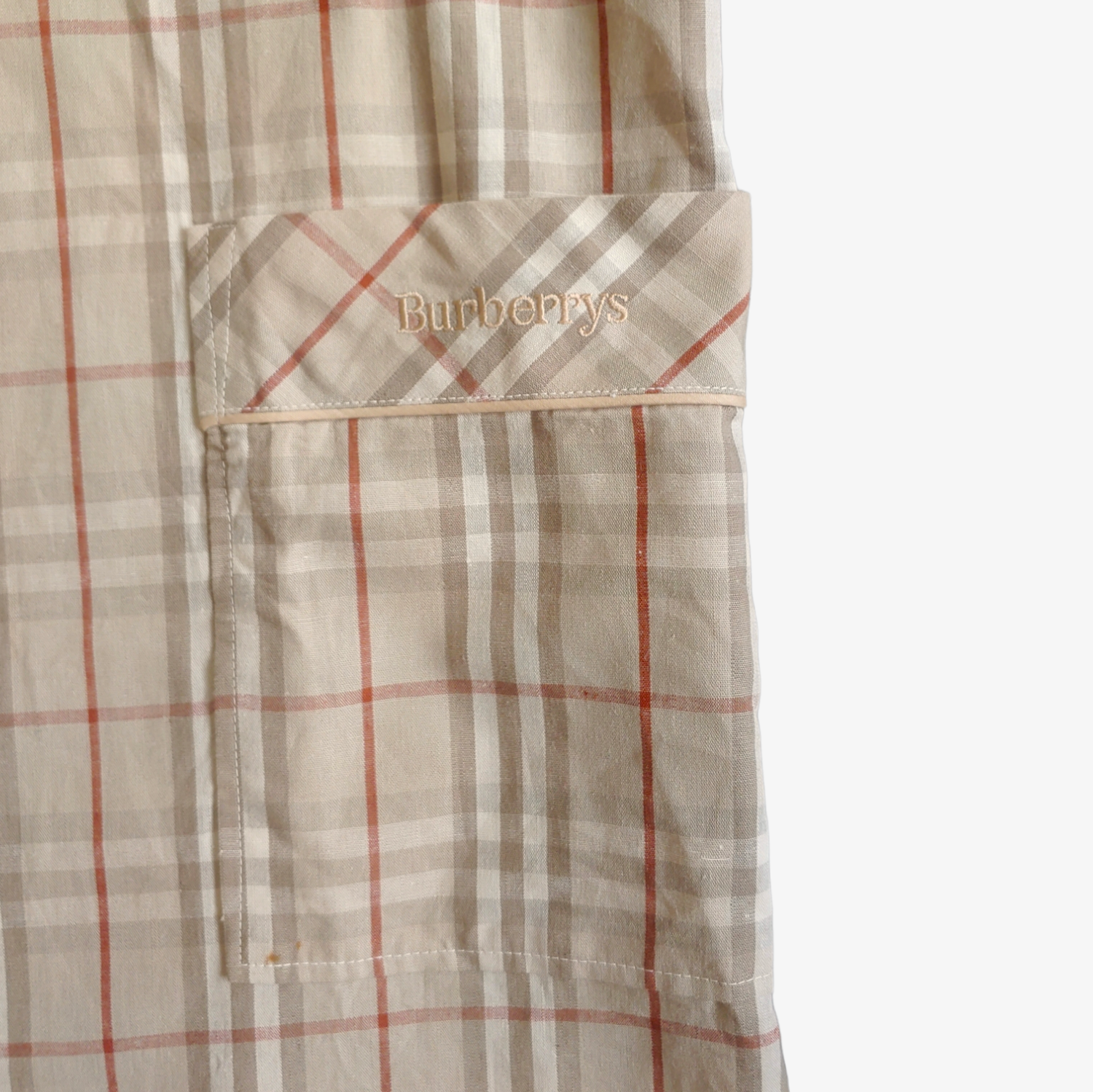 Embroidered spell out logo on vintage 1980s men's Burberry nova check robe in beige, brown, and grey checkered pattern.