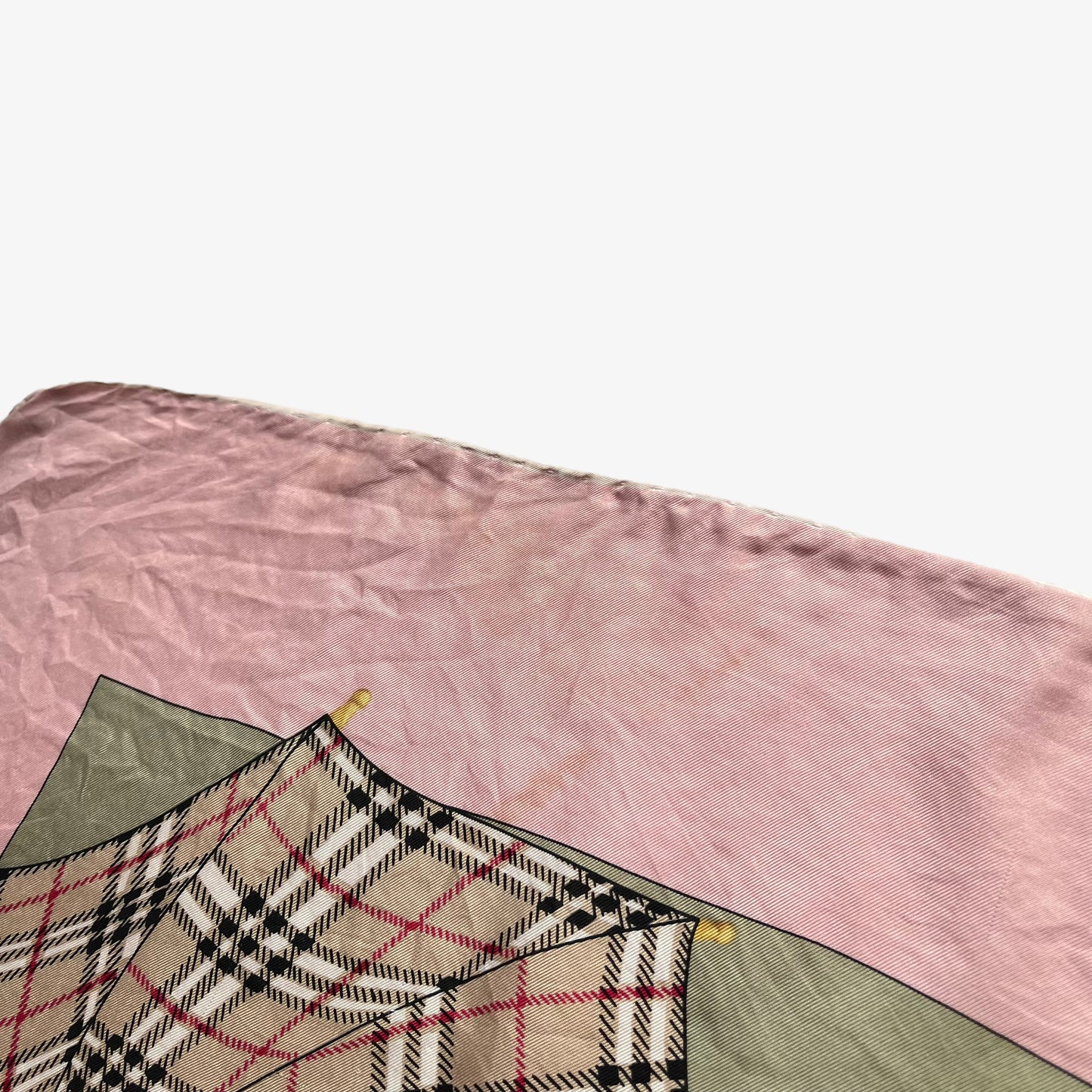 Hand rolled edges of women's vintage 80s Burberry nova check umbrella print pink silk scarf.