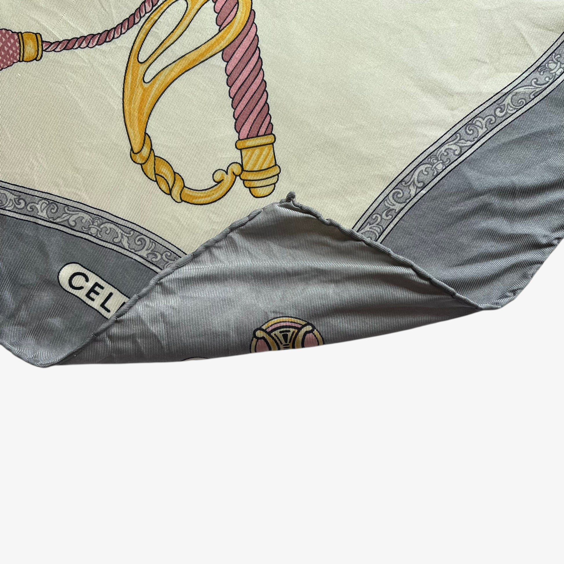 Hand rolled edges of women's vintage 80s Celine Paris grey silk scarf features a royal emblem and baroque sword print.