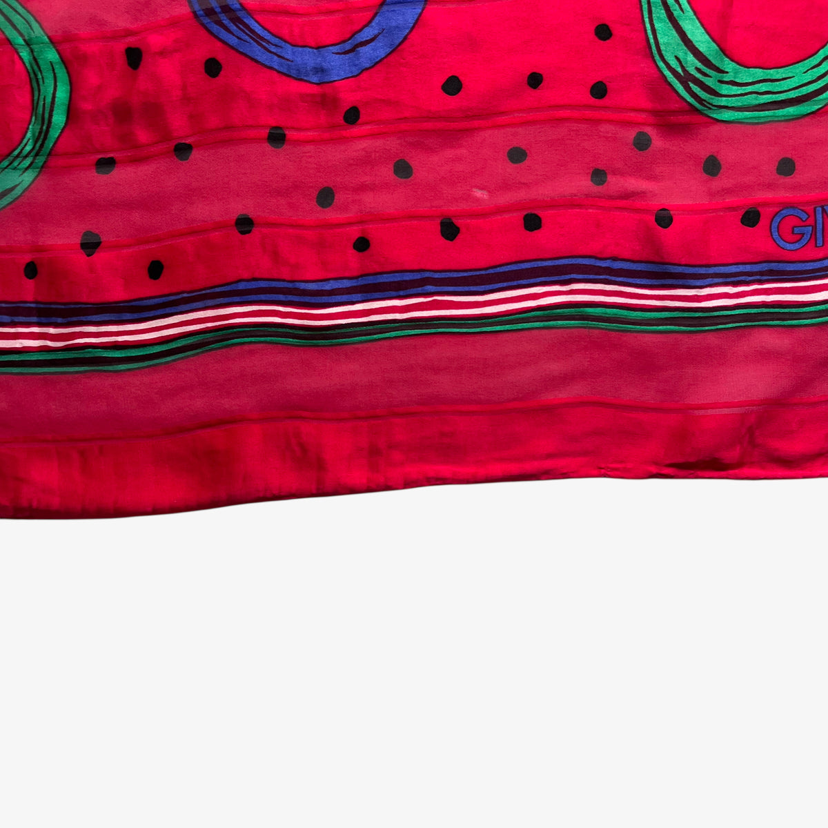Hem of vintage 80s Givenchy red silk scarf with colourful polka dot print.