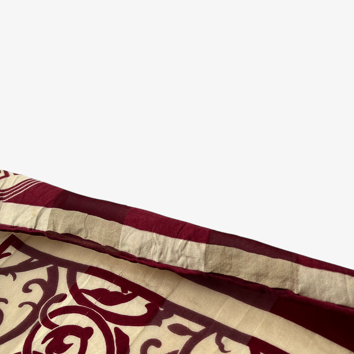 Hand rolled edge on a women's vintage 80s Givenchy red silk scarf with an abstract floral print.