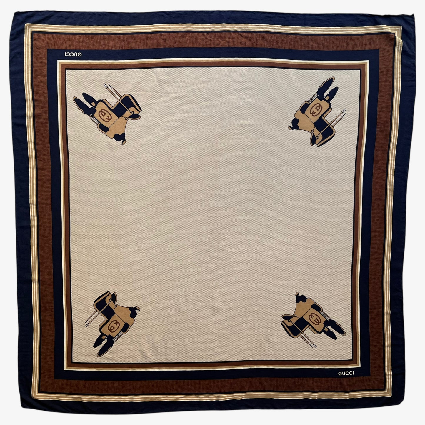 Women's vintage 80s Gucci equestrian saddle print brown silk scarf features a GG interlocking pattern.