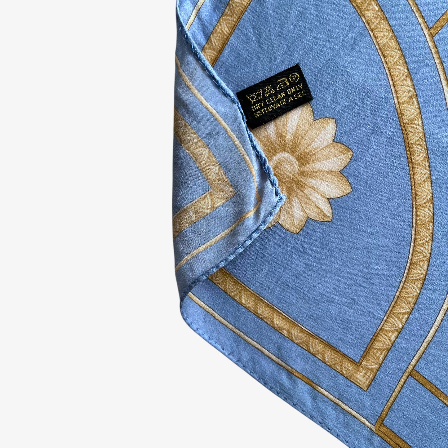 Hand rolled edge on women's vintage 80s Lanvin Paris gold art deco cat print blue silk scarf.