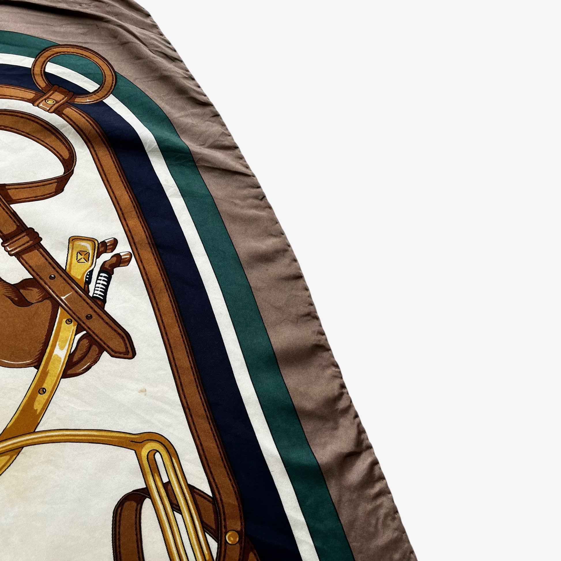 Hem of women's vintage 80s Longchamp equestrian and horseshoe print silk scarf.