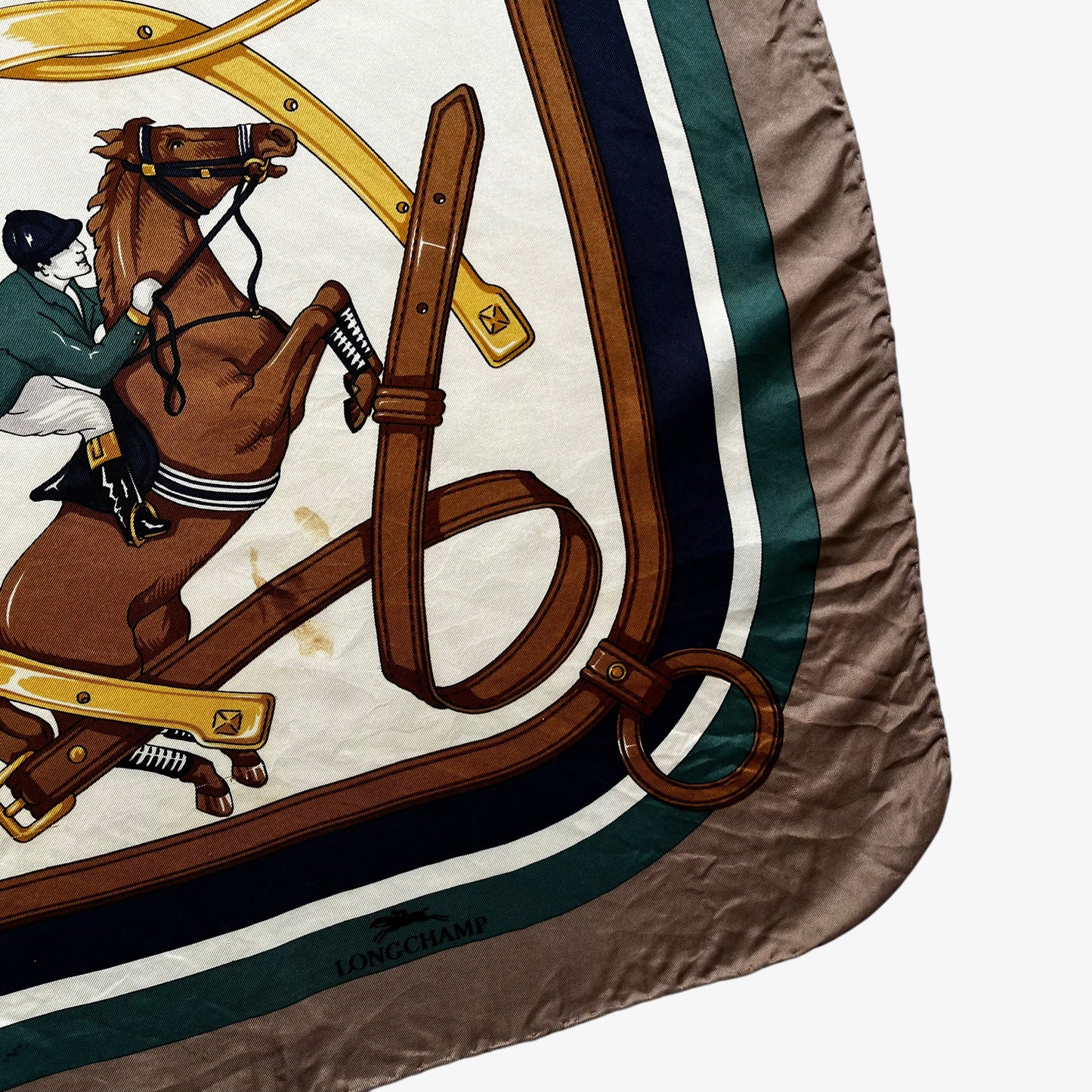 Patina on women's vintage 80s Longchamp equestrian and horseshoe print silk scarf.