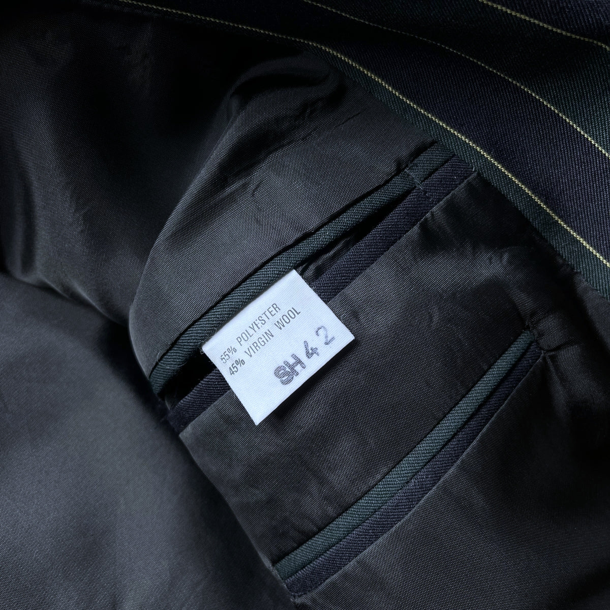 Close-up of a Beatties' blazer lining with a white size tag reading 55% polyester and 45% wool.