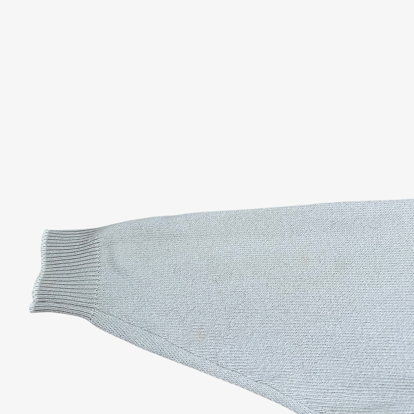 Ribbed cuff of vintage 80s Burberry men’s beige cable knit jumper with embroidered sailing motif.