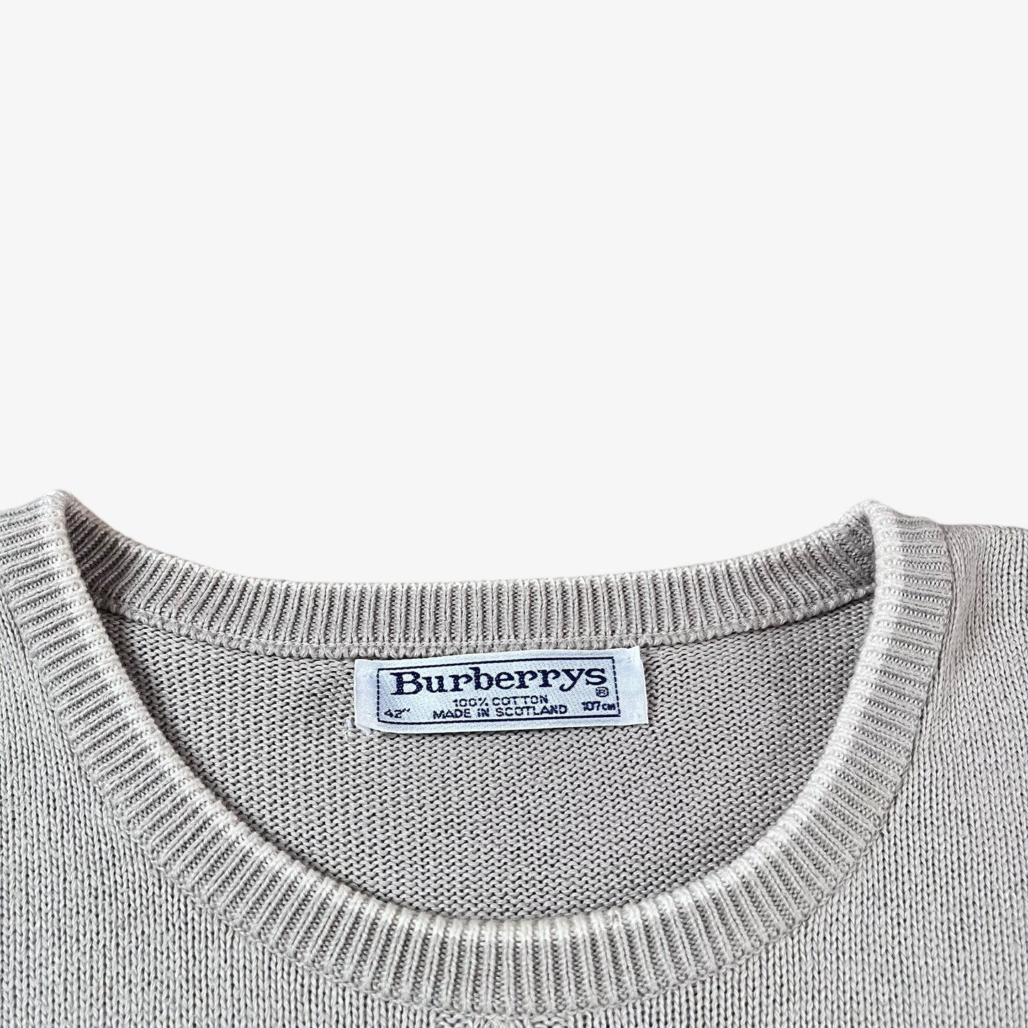 Label of vintage 80s Burberry men’s beige cable knit jumper with embroidered sailing motif.
