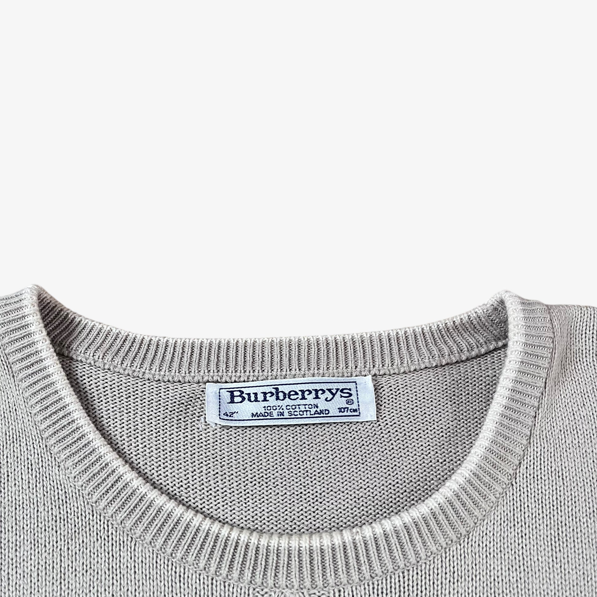 Label of vintage 80s Burberry men’s beige cable knit jumper with embroidered sailing motif.