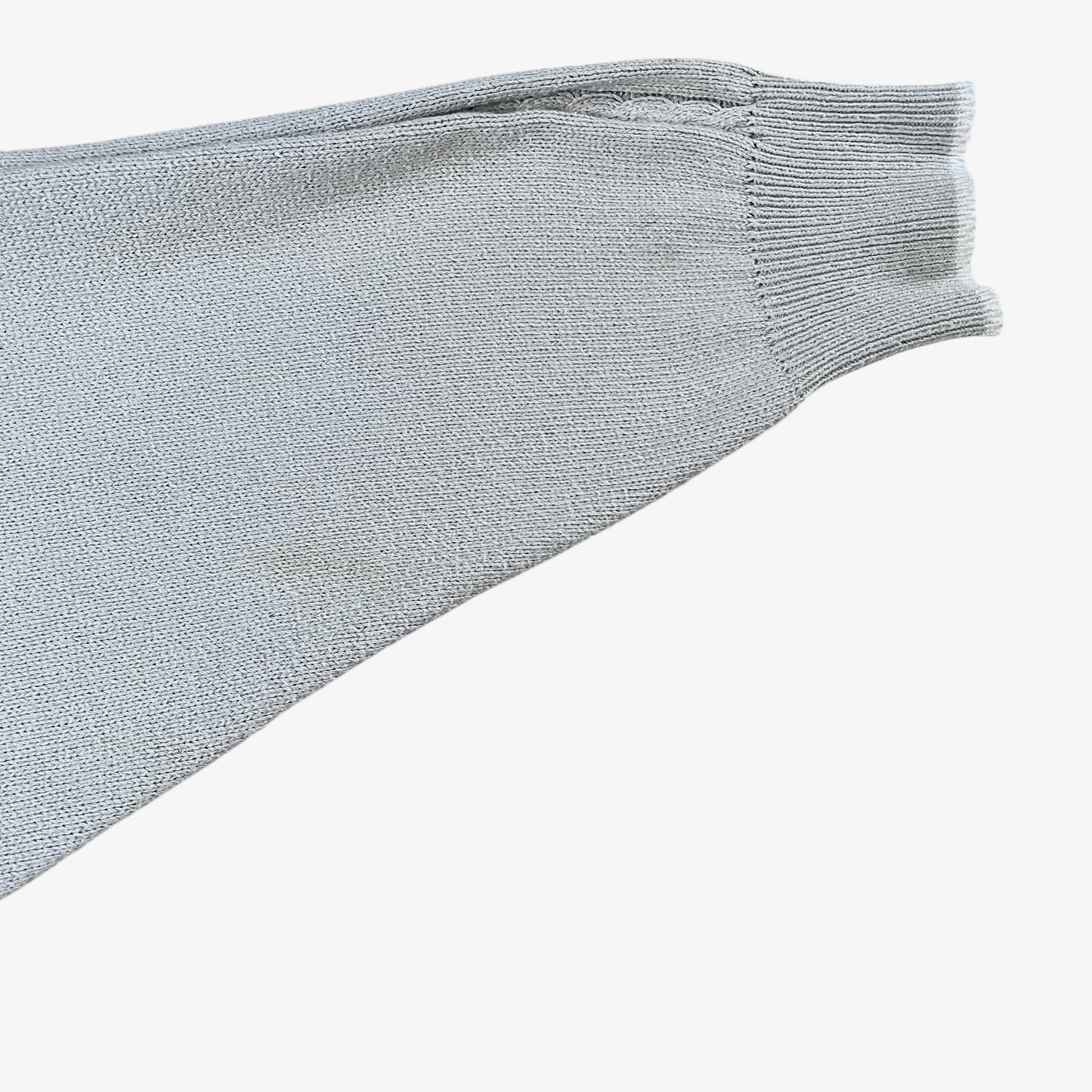 Sleeve of vintage 80s Burberry men’s beige cable knit jumper with embroidered sailing motif.