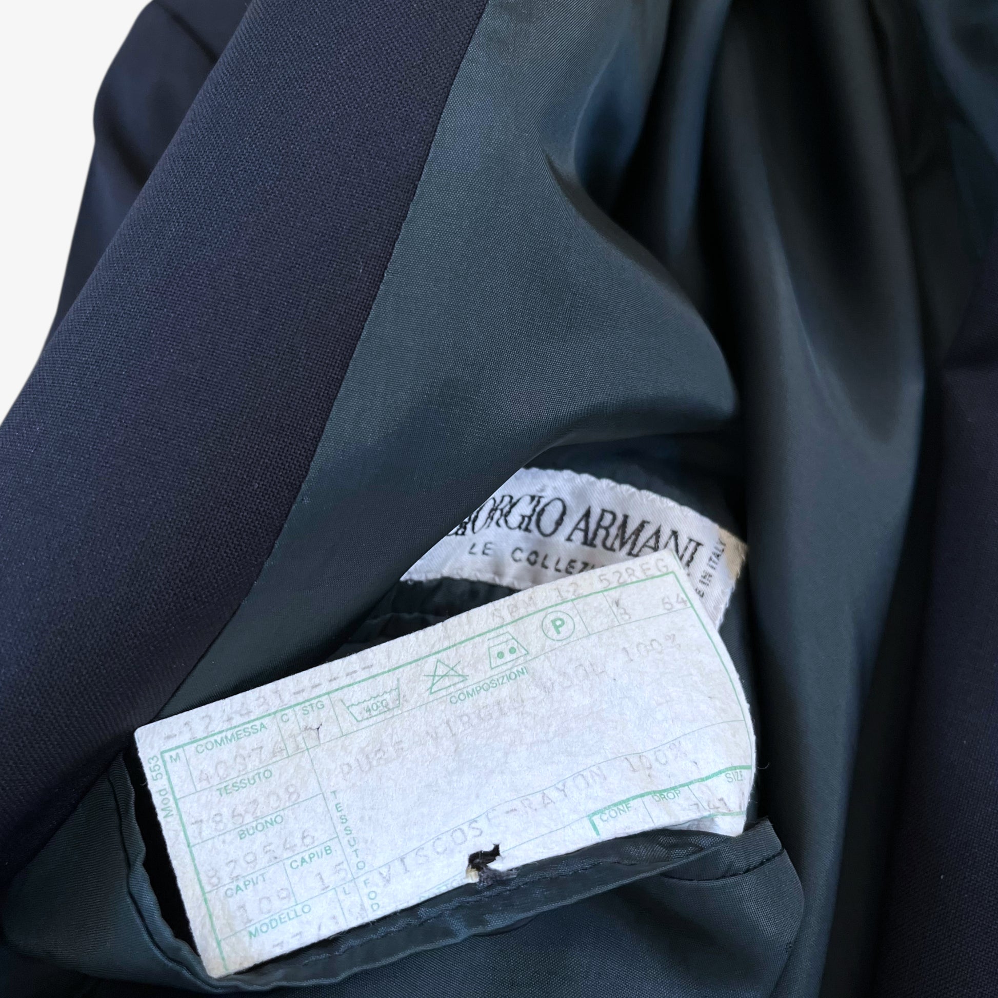 Care label stitched inside of men's vintage 80s Giorgio Armani Le Collezioni navy double breasted wool blazer.