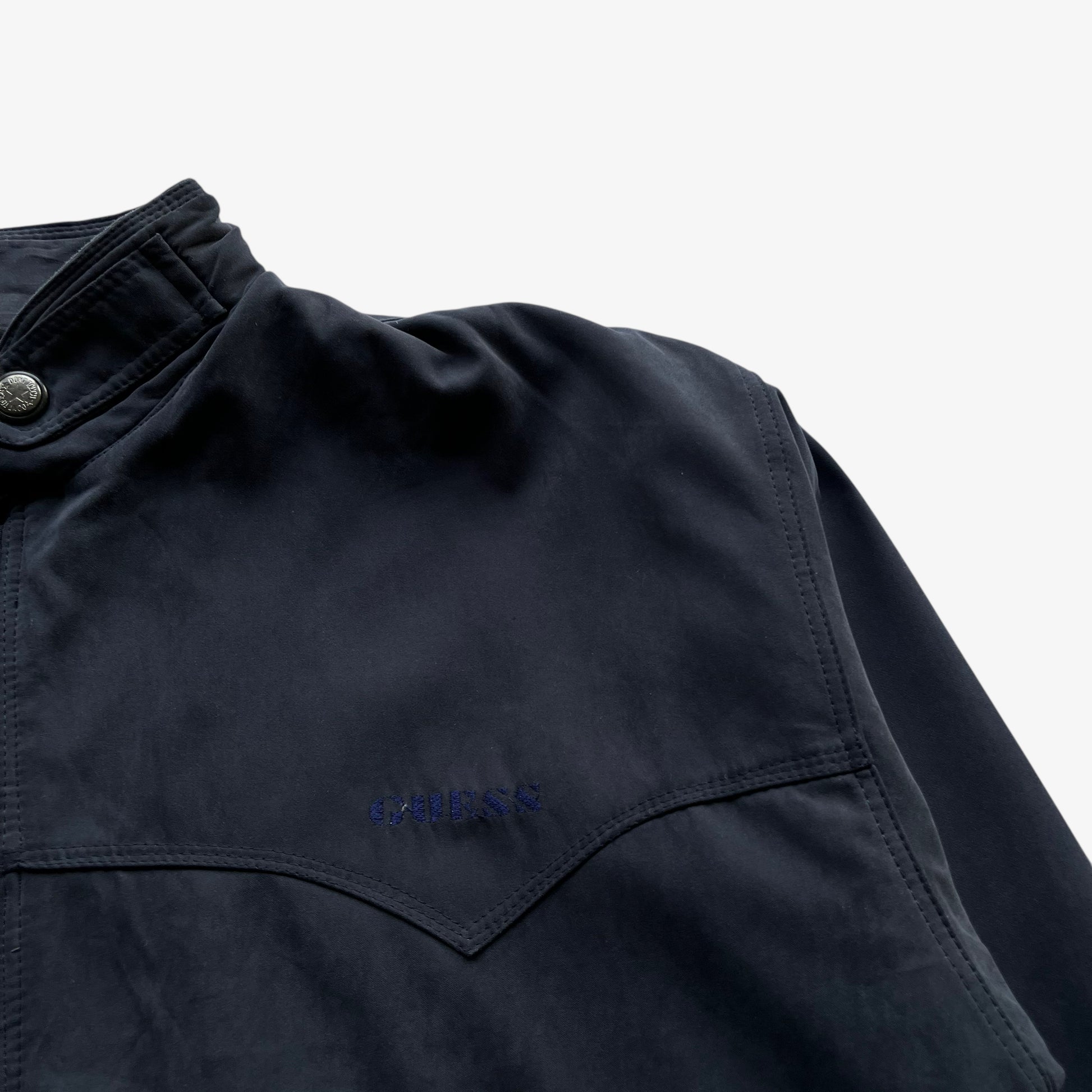 Guess embroidered spell out on men's vintage 80s Guess USA navy driving jacket.