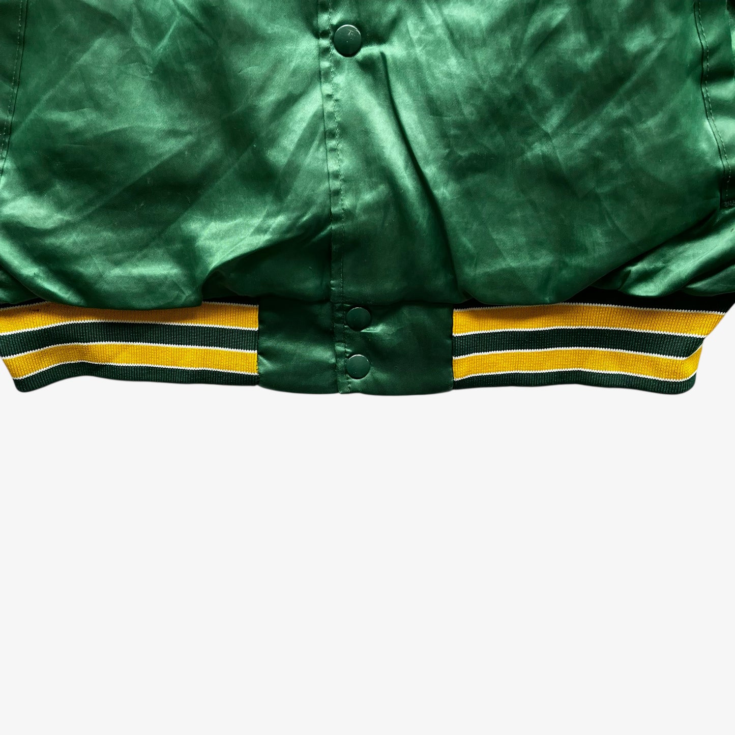 Hem of vintage 80s men's Swingster MLB Oakland Athletics green varsity jacket.
