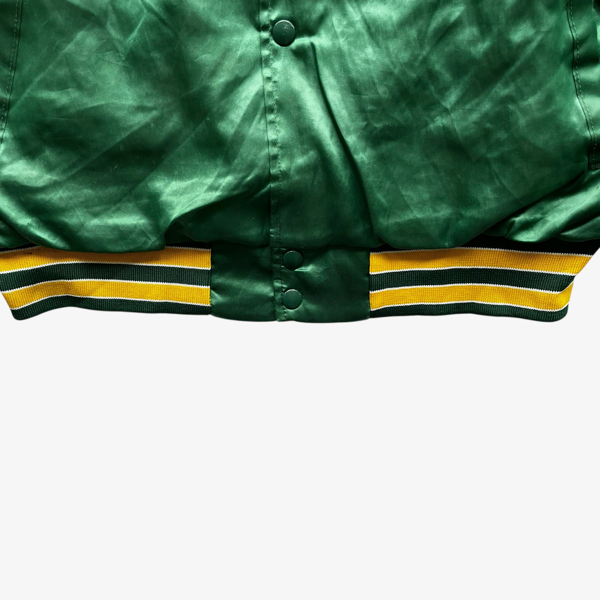 Hem of vintage 80s men's Swingster MLB Oakland Athletics green varsity jacket.