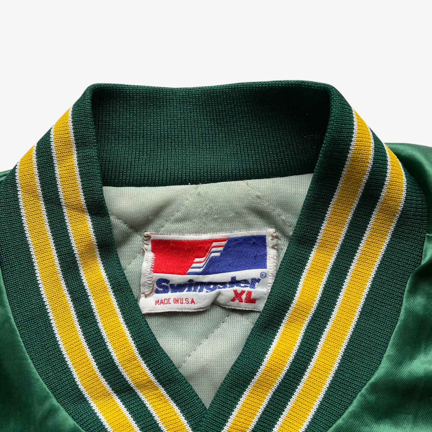Swingster made in USA label inside of Vintage 80s men's MLB Oakland Athletics green varsity jacket.