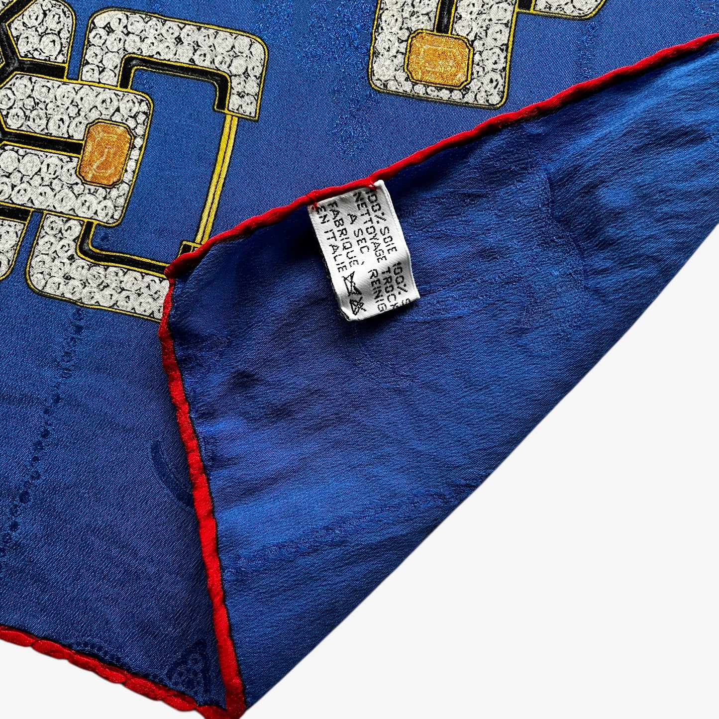 Made in Italy label on women's vintage 80s Must de Cartier interlocking cc print blue silk scarf with a red jewelled belt trim.