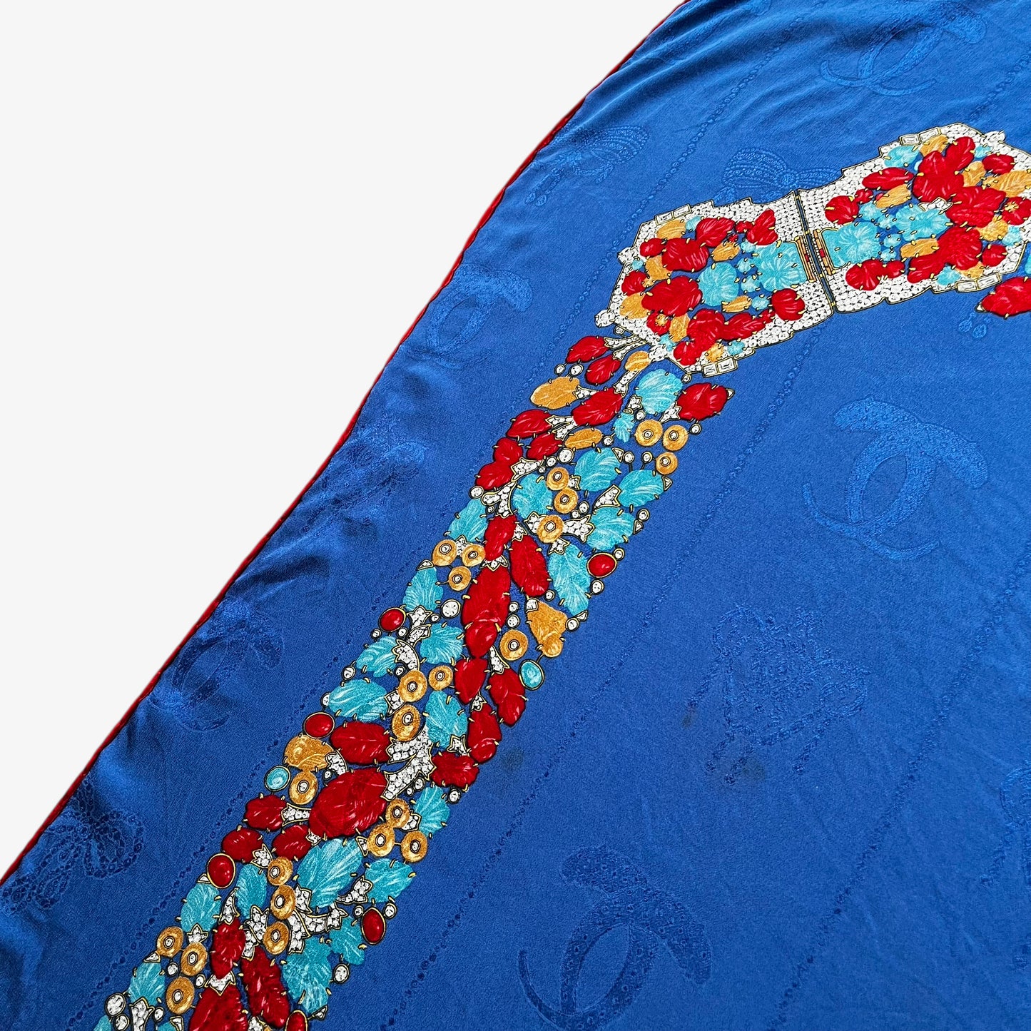 Patina on women's vintage 80s Must de Cartier interlocking cc print blue silk scarf with a red jewelled belt trim.