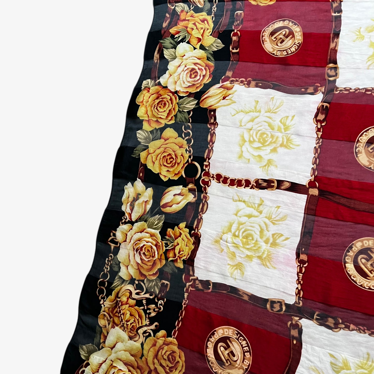 Close up of a yellow floral print on a women's vintage 80s Paolo Gucci black silk scarf featuring a checkered and equestrian buckle print.