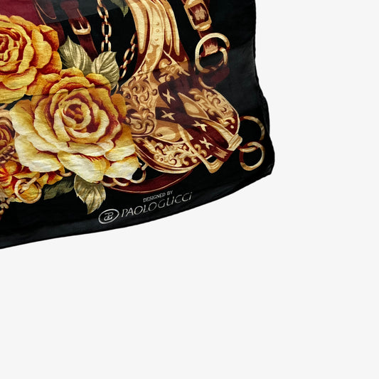 Paolo Gucci printed logo on women's vintage 80s black silk scarf featuring a checkered floral and equestrian buckle pattern.