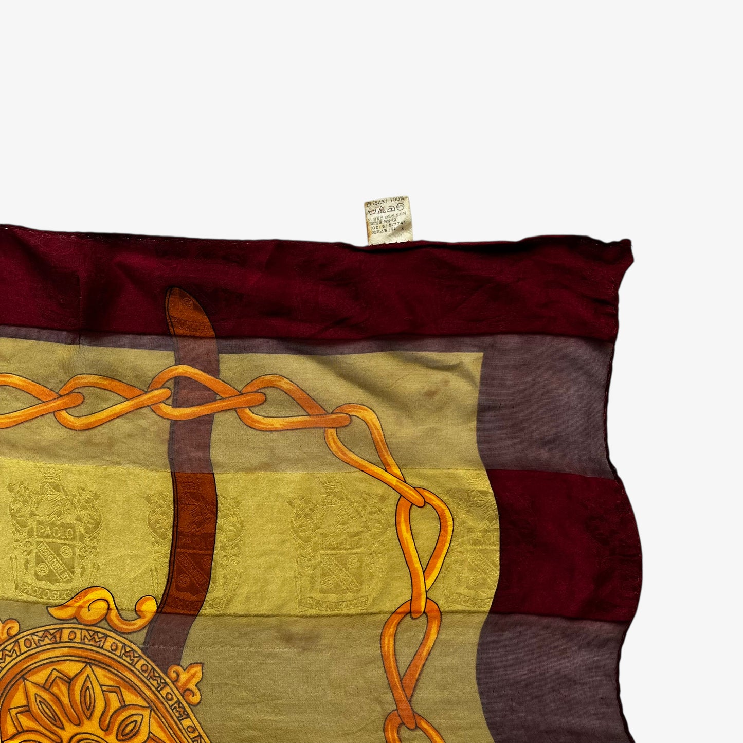 Label on vintage 80s women's equestrian buckle and embossed crest print silk scarf featuring a green and red stripe.