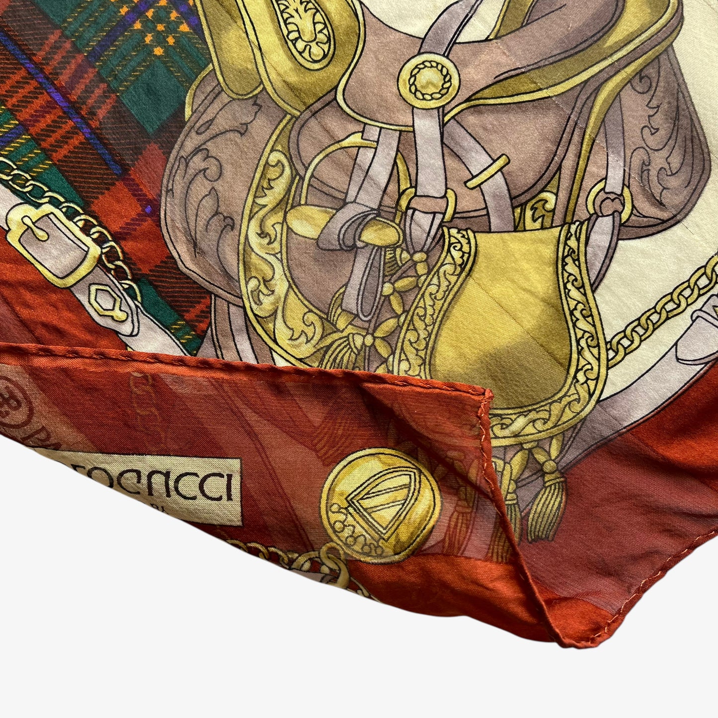 Sewn edges on women's vintage 80s Paolo Gucci equestrian saddle print red silk scarf featuring a green tartan stripe.