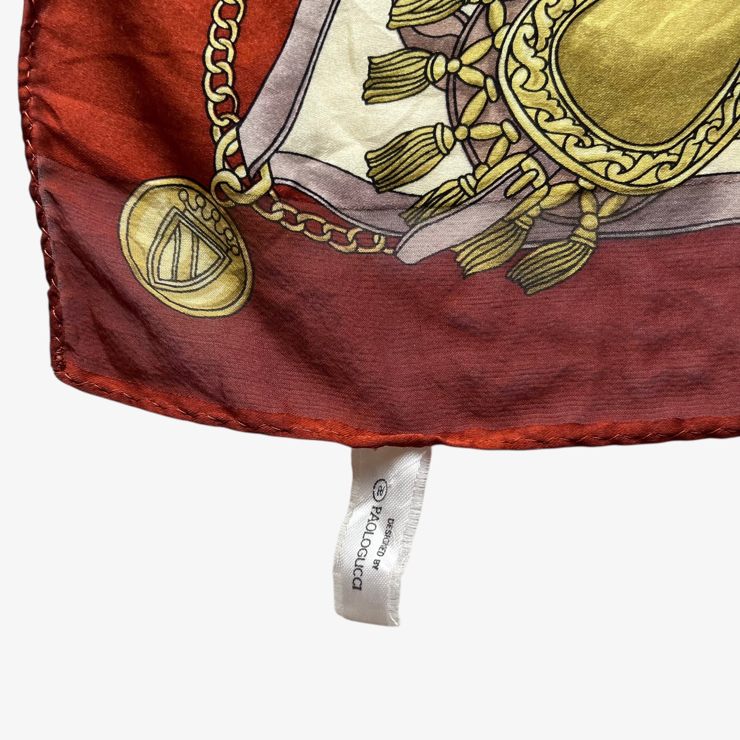 Paolo Gucci label on women's vintage 80s equestrian saddle print red silk scarf featuring a green tartan stripe.