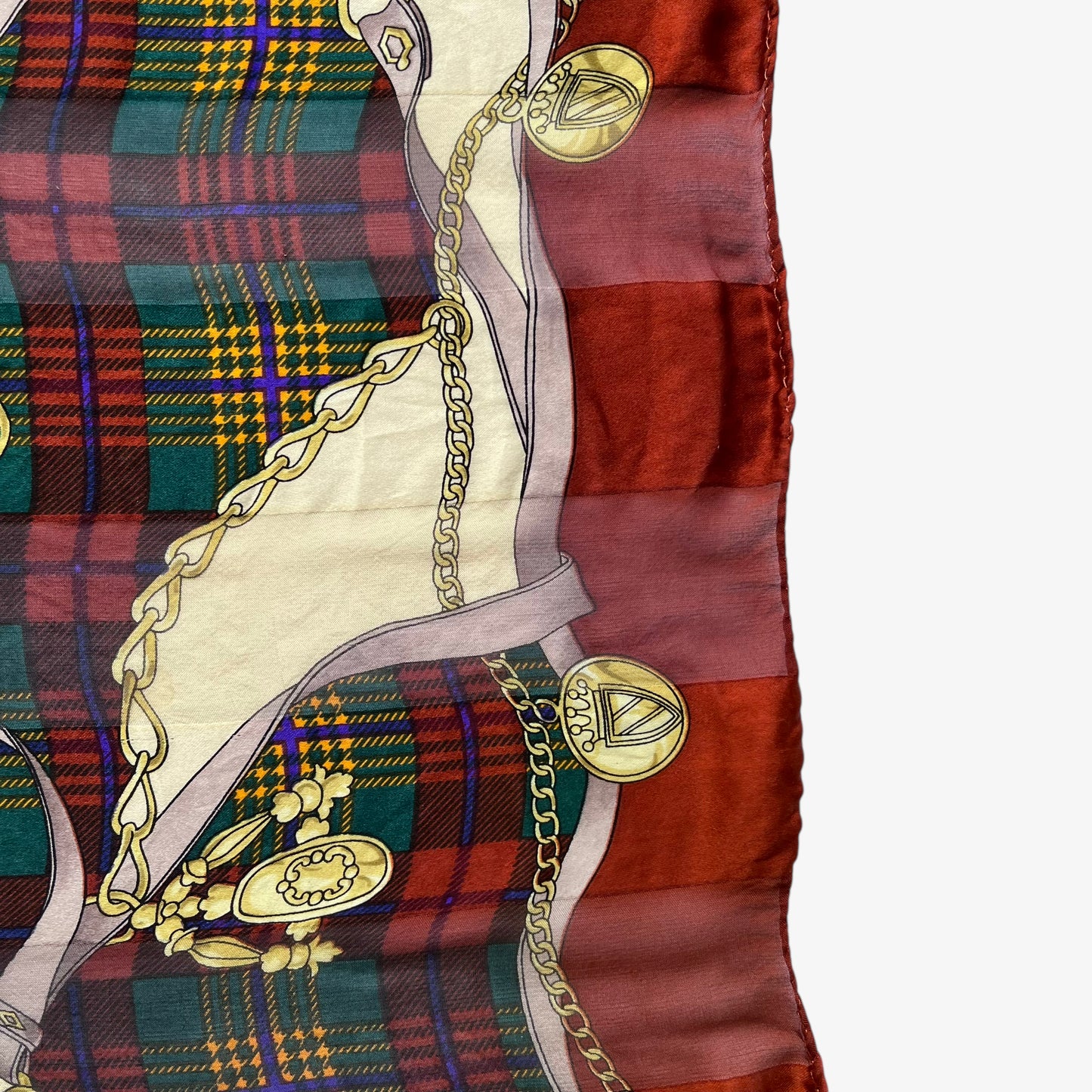 Hem of women's vintage 80s Paolo Gucci equestrian saddle print red silk scarf featuring a green tartan stripe.