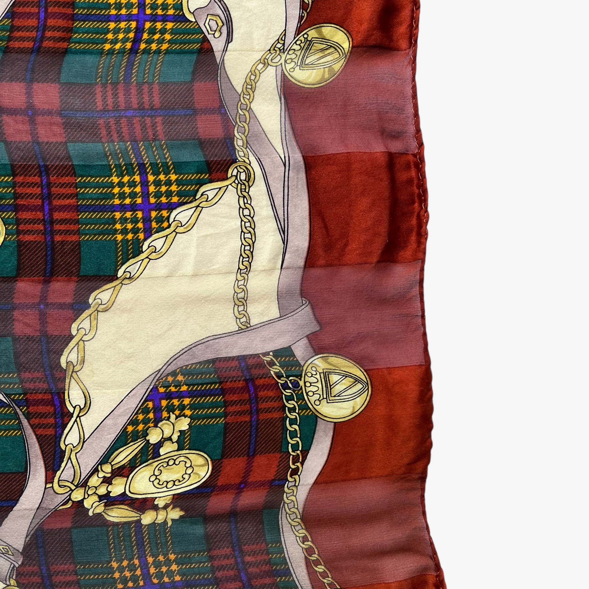 Hem of women's vintage 80s Paolo Gucci equestrian saddle print red silk scarf featuring a green tartan stripe.