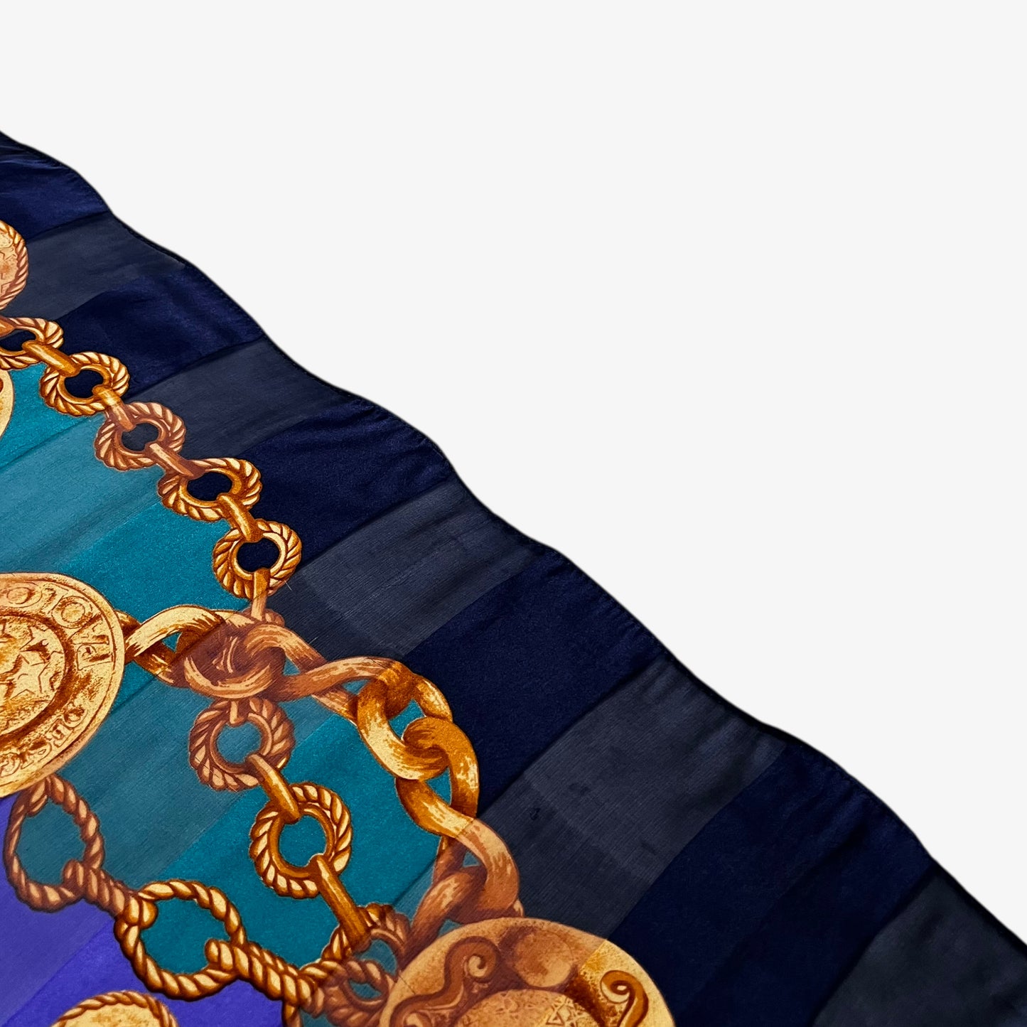 Hem of women's vintage 90s Paolo Gucci gold medallion chain print green and purple silk scarf.