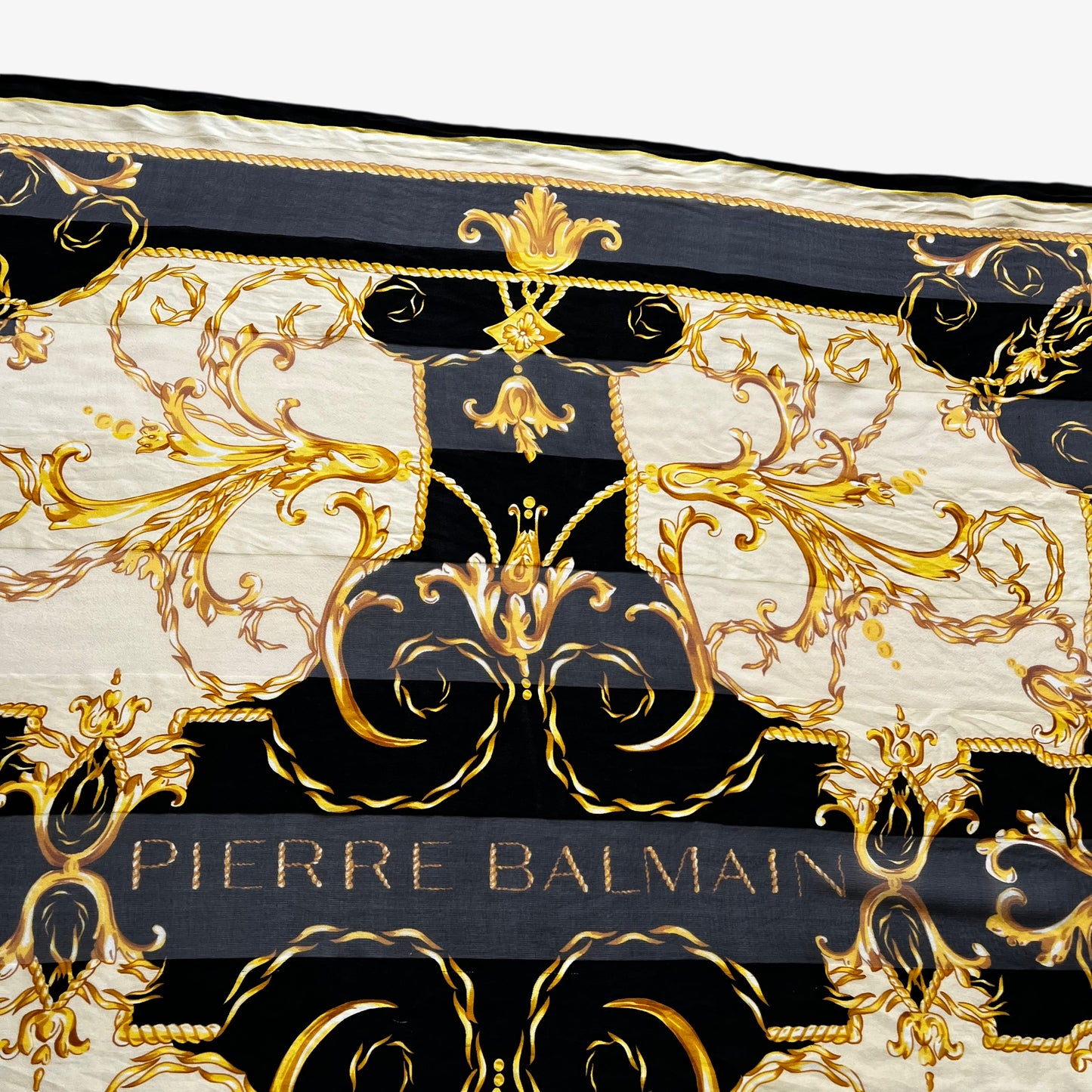Patina on vintage 80s women's Pierre Balmain gold baroque spell out print black silk scarf.