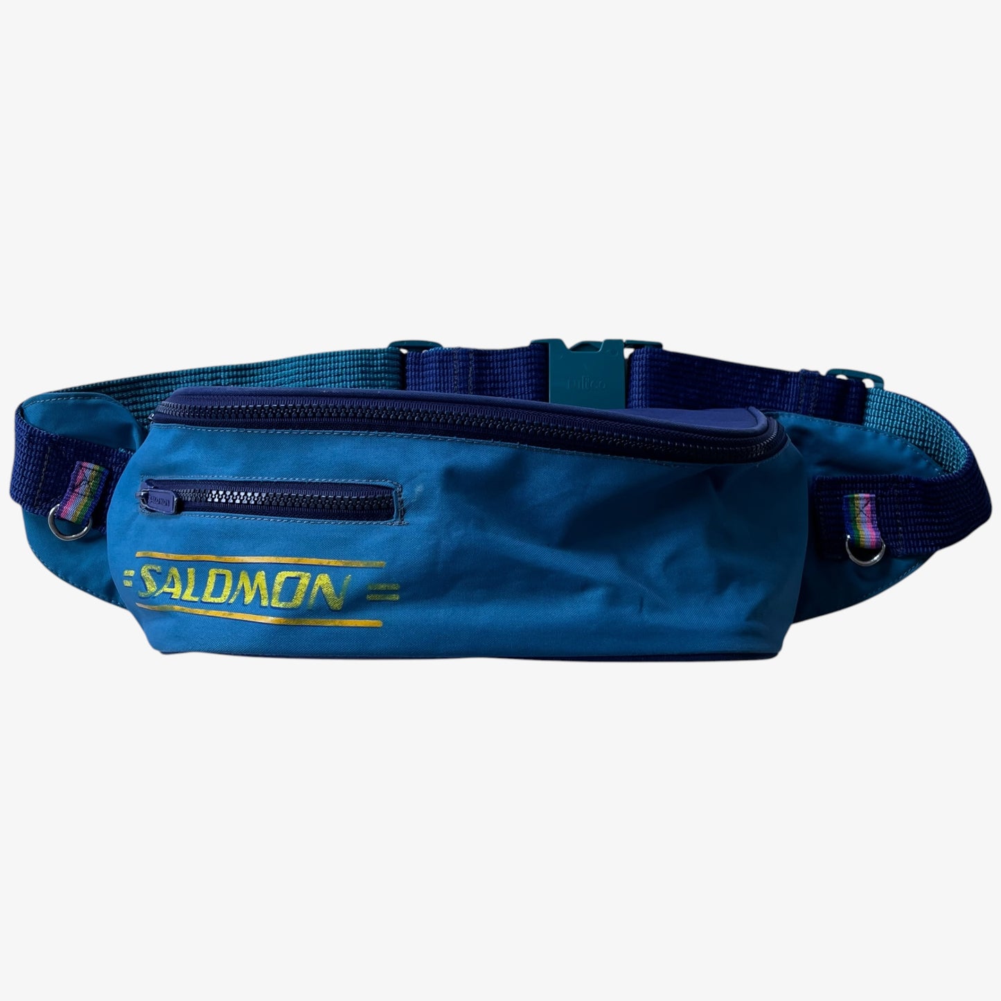 Vintage Salomon blue bum bag with spell out logo branding on a white background.