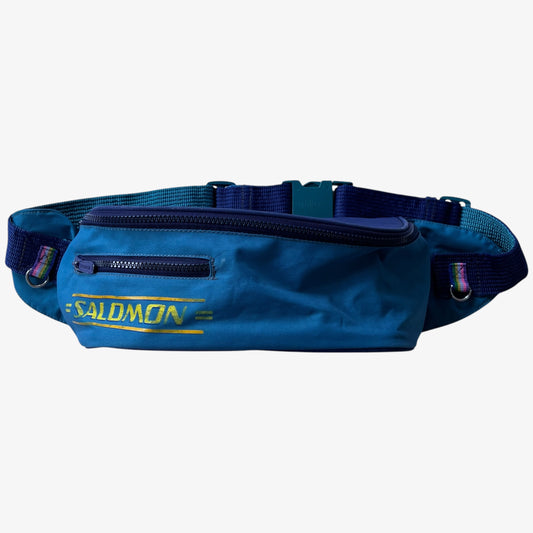 Vintage Salomon blue bum bag with spell out logo branding on a white background.